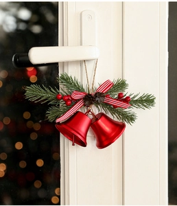 Detail von roten Weihnachtsglocken mit Tannennadeln, Zapfen und Schleife an einer Tür