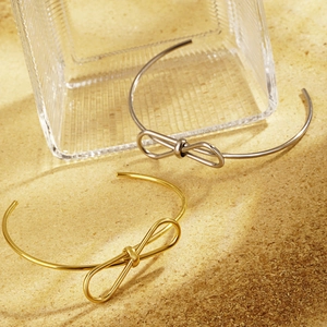 Minimalist knot bow open cuff bracelet in polished gold and silver stainless steel finish