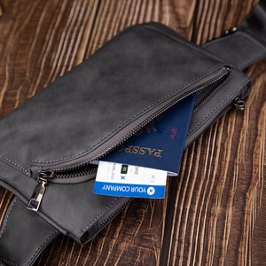 Macro shot of matte gray crossbody bag with textured fabric and dark metal zippers