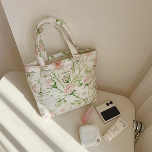 Detailed macro of floral quilted tote bag with pink rose print and fabric label