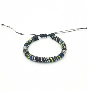 Detail of bohemian hand-woven surfing bracelet with colorful stripes and adjustable knot