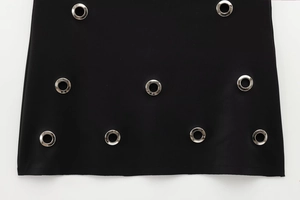 Détail d'un tissu noir de haute qualité avec des accents décoratifs d'œillets métalliques