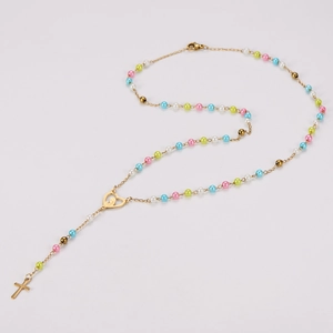 Détail du collier de perles colorées avec pendentif croix et fermoir coeur
