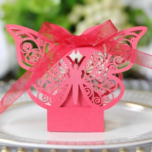 Macro shot of red laser-cut butterfly gift box with ribbon detail and floral background