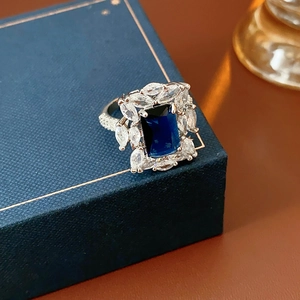 Détail macro d'une pierre bleue saphir rectangulaire avec des zircons marquise sur l'anneau