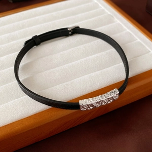 Close-up of black pleated leather bracelet with engraved silver rectangular buckle