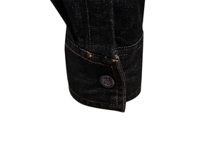 Gros plan détaillé du poignet d'une chemise en jean foncé avec boutons métalliques