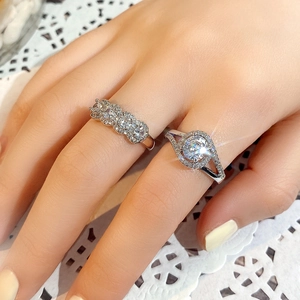 Detail of silver engagement ring set featuring halo round cut and pavé stones on hand