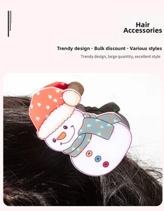 Detail view of a cute snowman hair claw clip with a red polka dot hat on dark hair