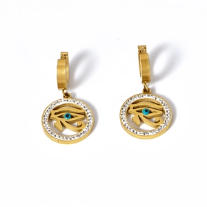 Gold Eye of Horus earrings with white rhinestones and blue center on white background