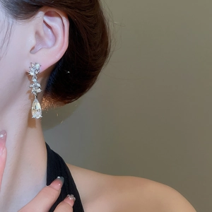 Close-up of elegant silver drop earrings with marquise-cut rhinestones and pear-shaped crystals