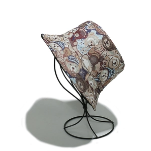 Detail view of jacquard bucket hat featuring cute colorful teddy bear patterns on a stand