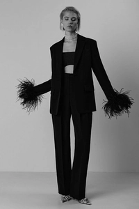 Close-up of black suit jacket featuring luxurious faux feather trim on the sleeve cuffs