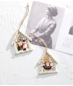 Detail of Christmas resin house ornament with relief snowman and Santa Claus patterns