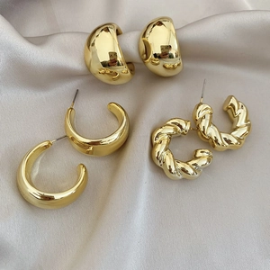 Detailed set of three golden hoop earrings including smooth C-shape and twisted rope textures