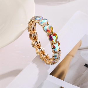 Makroaufnahme des elastischen Herz-Armbands mit Aurora-Glassteinen und Goldfassung