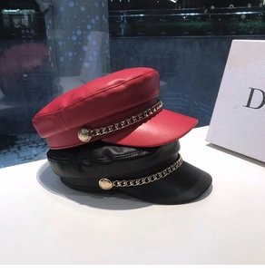 Detail of red and black PU leather baker boy hats with decorative gold chains