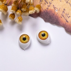 Detail view of 12x16mm yellow acrylic doll eyes with realistic radial iris on white background