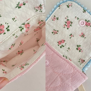 Detail view of cotton floral case lining and snap button closure for mini cameras