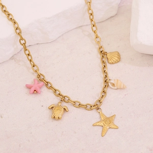 Macro shot of gold stainless steel necklace featuring starfish, turtle, and shell charms
