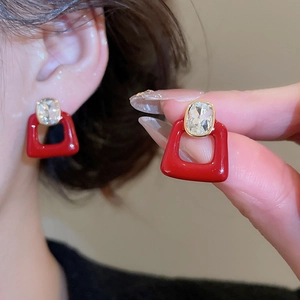 Detail of red zircon stud earrings with gold plating and vintage geometric design