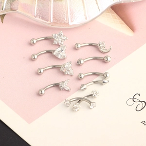 Detail of silver stainless steel curved barbells with heart, star and moon zircon studs