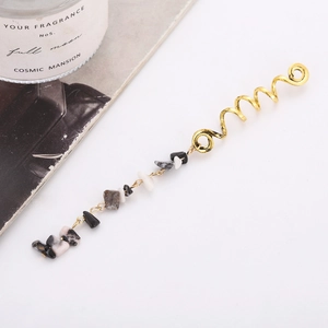 Detail of gold spiral hair jewelry with hanging black and white natural stone pendants