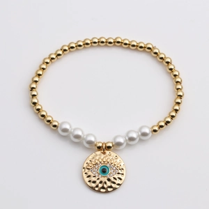 Bracelet en perles dorées et blanches avec pendentif de protection œil bleu