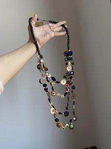 Detail of bohemian multilayer long necklace with colorful shell discs and black beads