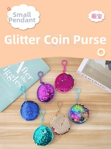 Detail of colorful round sequin coin purses with hooks scattered on a light wooden table