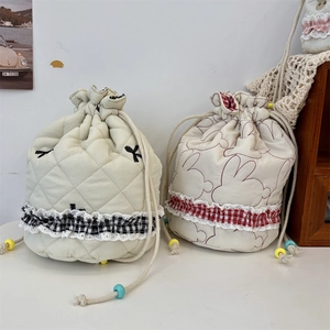 Quilted drawstring cosmetic bags with rabbit prints and plaid lace trim on white desk