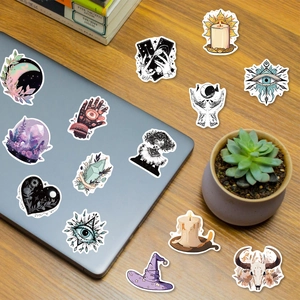 Macro view of mystic wizard stickers with moon and crystals on a laptop and wooden desk