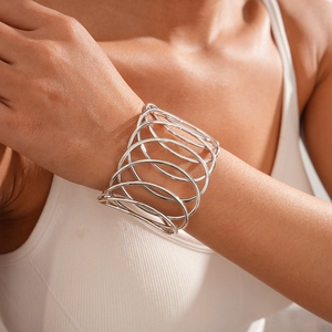 Macro shot of silver layered geometric intertwined open cuff bracelet on wrist