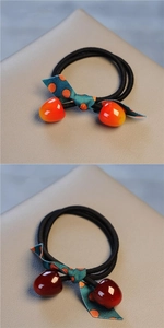 Detail of cute hair ties with polka dot bows and colorful fruit charms in cherry design