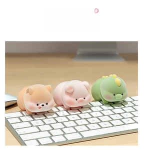 Furry Shiba Inu, pig, and dinosaur mini figurines on a white office keyboard
