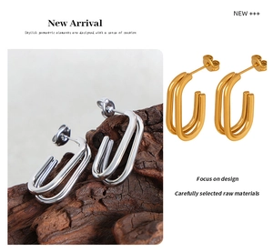 Detail of geometric U-shaped long stud earrings in polished gold and silver metal finishes