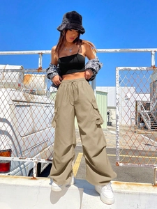 Outdoor low-angle view of khaki cargo pants with drawstring waist and side utility pockets