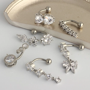 Detailed close-up of six stainless steel belly rings with cz heart and butterfly shapes