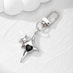 Detailed macro view of silver star keychain featuring a faceted black heart gemstone