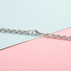 Detailed close-up of a silver stainless steel cuban link chain with a lobster clasp