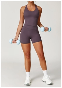 Dettaglio del set yoga viola scuro con top incrociato dietro e pantaloncini fitness