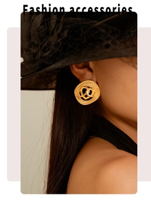 Dettaglio di orecchini vintage a cuore intrecciato dorato su modella con cappello nero