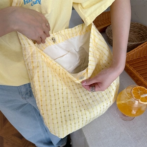 Détail de l'intérieur du sac cabas à carreaux jaunes avec boucle magnétique et poche zippée