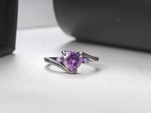 Macro shot of purple heart-shaped zircon set in elegant black gold plated ring band