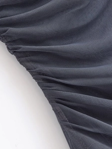 Detailed macro view of black mesh fabric showing fine pleated texture and netted structure