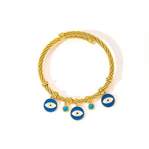 Detail of twisted cable gold bracelet with five blue evil eye charms in polished finish
