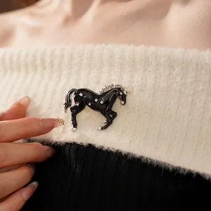 Vintage horse brooch with black enamel and rhinestones on a knit sweater