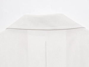 Detailed close-up of white cotton linen bomber jacket collar and back stitching texture