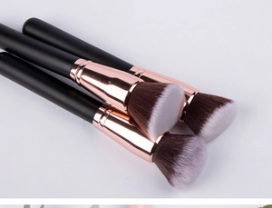 Detailed macro of black and rose gold makeup brushes for foundation and powder