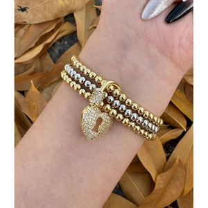 Bracciale a tre strati con perle oro e argento e ciondolo a lucchetto a cuore sul polso